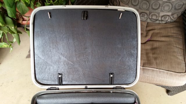The divider secured to the top side of the suitcase. 