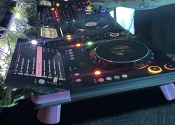 TriMixxx, a DIY CDJ, sitting on a DJ booth next to other DJ gear.
