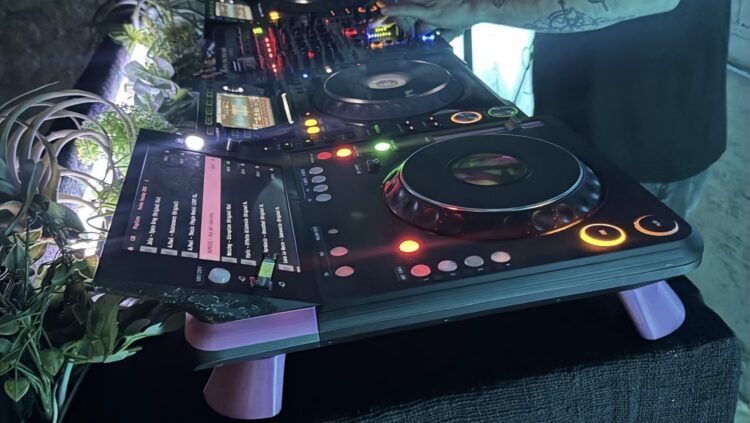 TriMixxx, a DIY CDJ, sitting on a DJ booth next to other DJ gear.